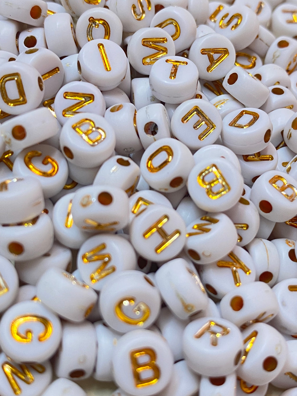 Cuentas de letras blancas con dorada